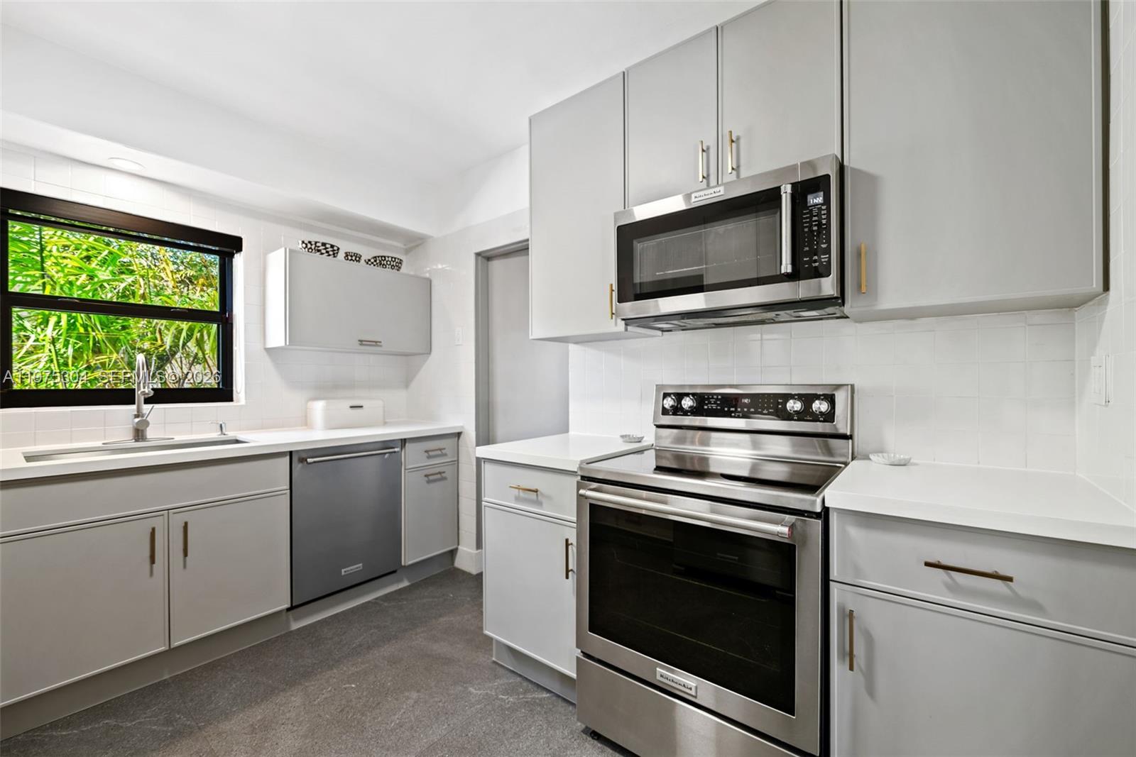 740 Northeast 76th Street Miami, FL 33138 - Photo 29 of 43 a kitchen with stainless steel appliances a stove microwave and sink