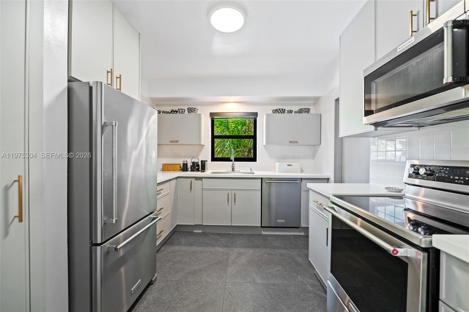 740 Northeast 76th Street Miami, FL 33138 - Photo 30 of 43 a kitchen with a refrigerator stove and microwave