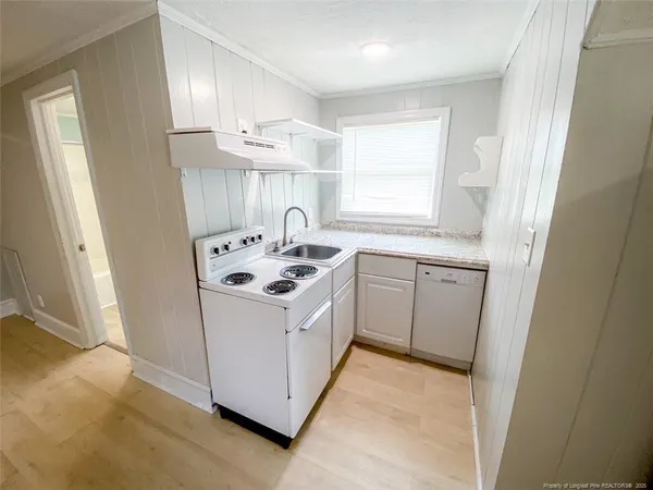 a kitchen with a sink a stove a refrigerator and cabinets