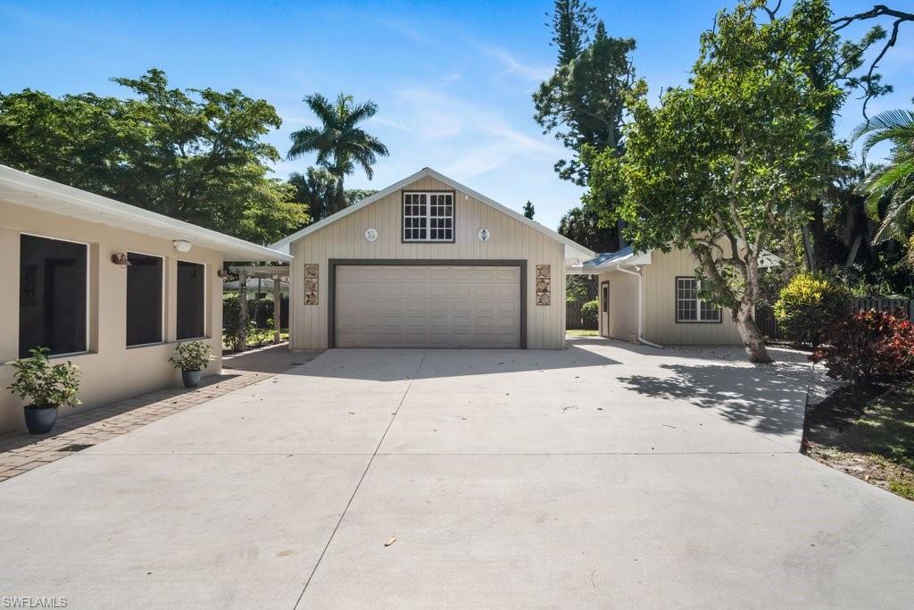 2300 North Road Naples, FL 34104 - Photo 5 of 20 a view of a house with a yard and garage