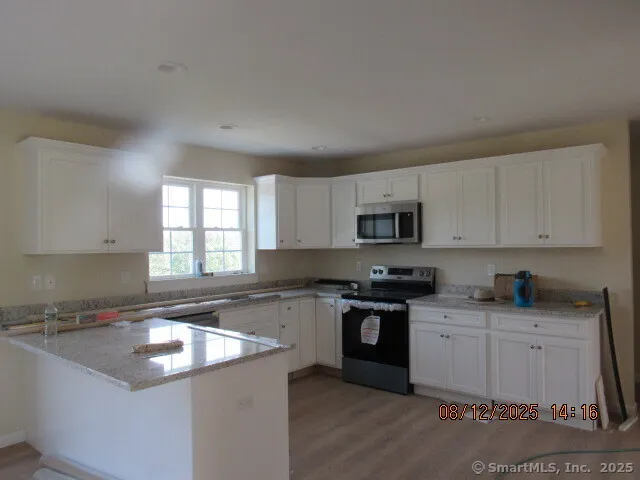 a kitchen with stainless steel appliances granite countertop a sink stove and cabinets