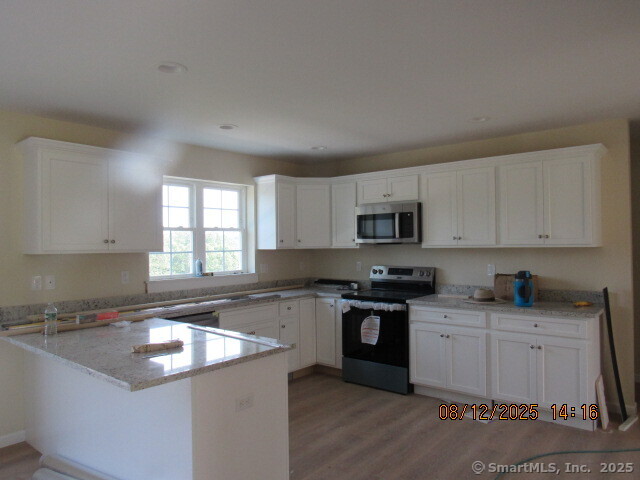 31 Warm Earth Road Naugatuck, CT 06770 - Photo 4 of 36 a kitchen with stainless steel appliances granite countertop a sink stove and cabinets