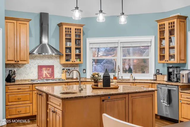 a kitchen with stainless steel appliances granite countertop a sink a stove and refrigerator