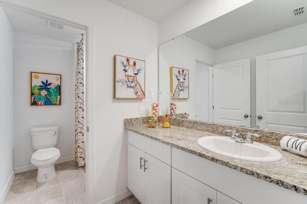 13812 Shellmore Avenue Palmetto, FL 34221 - Photo 23 of 30 a bathroom with a granite countertop sink toilet and a mirror