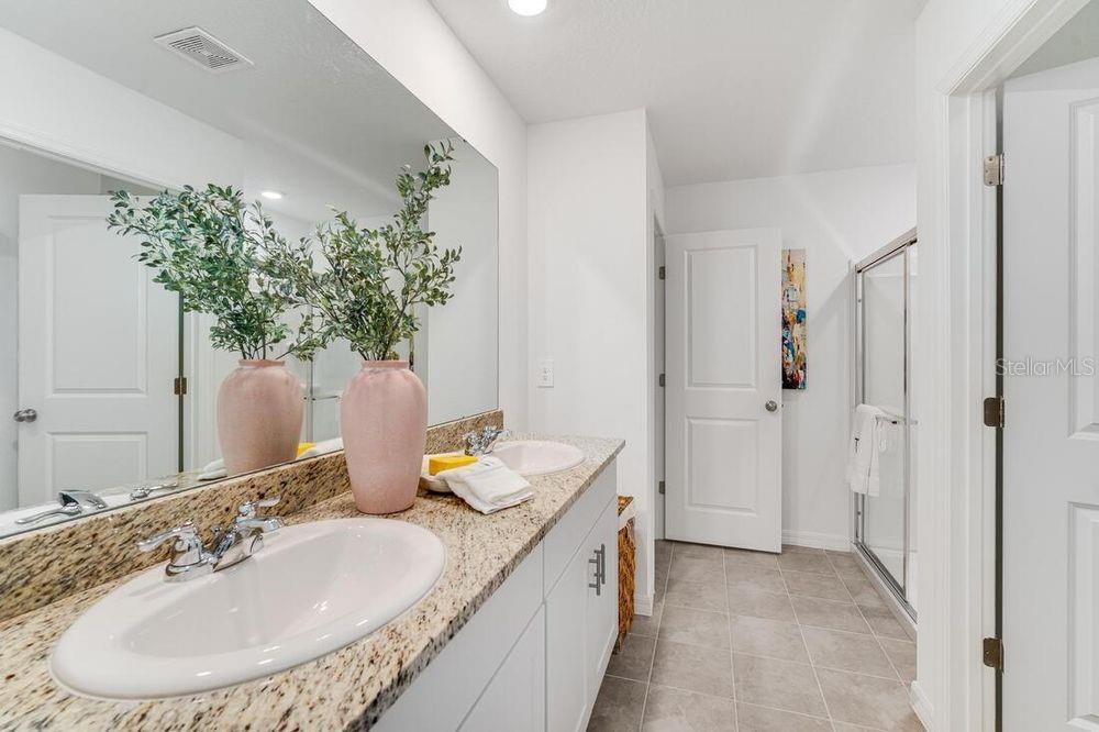 13812 Shellmore Avenue Palmetto, FL 34221 - Photo 25 of 30 a bathroom with a granite countertop sink a mirror and a shower