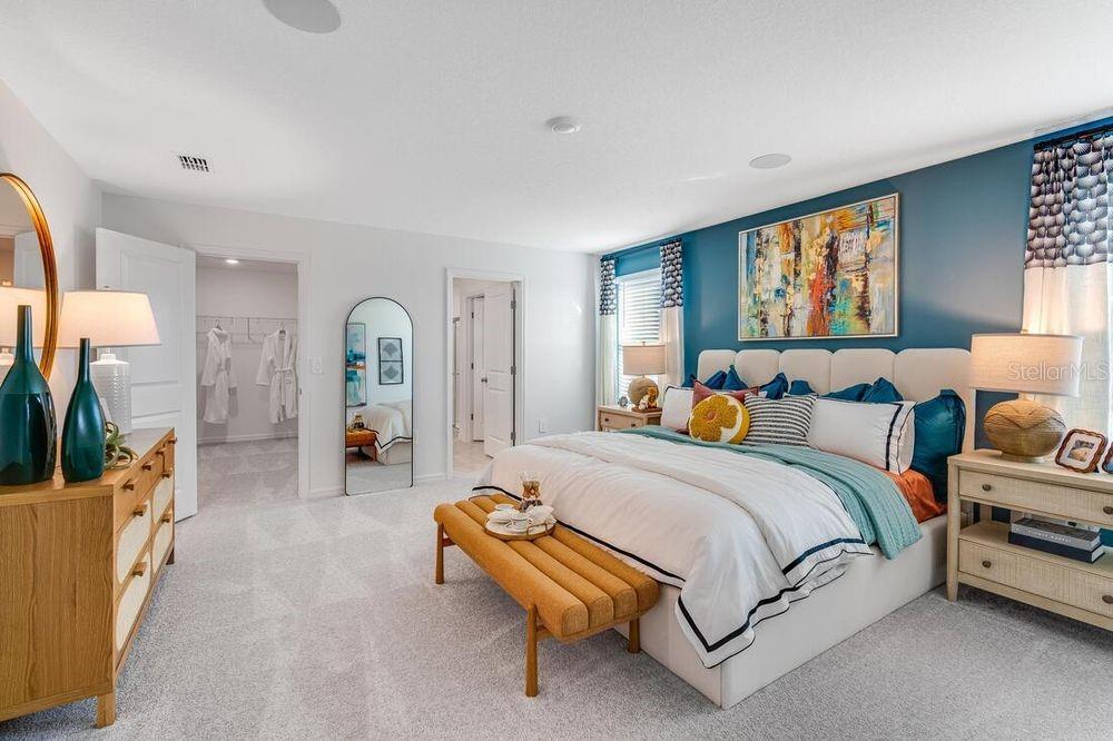 13812 Shellmore Avenue Palmetto, FL 34221 - Photo 29 of 30 a spacious bedroom with a bed a couch and a flat tv screen on dresser