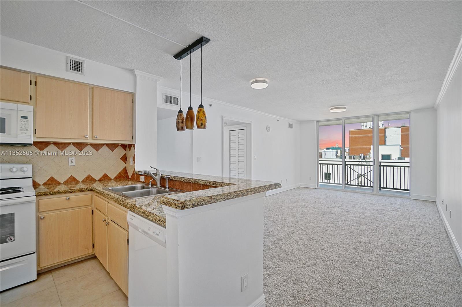 2665 Southwest 37th Avenue, Unit 914 Miami, FL 33133 - Photo 2 of 30 a kitchen with a stove a sink and a refrigerator