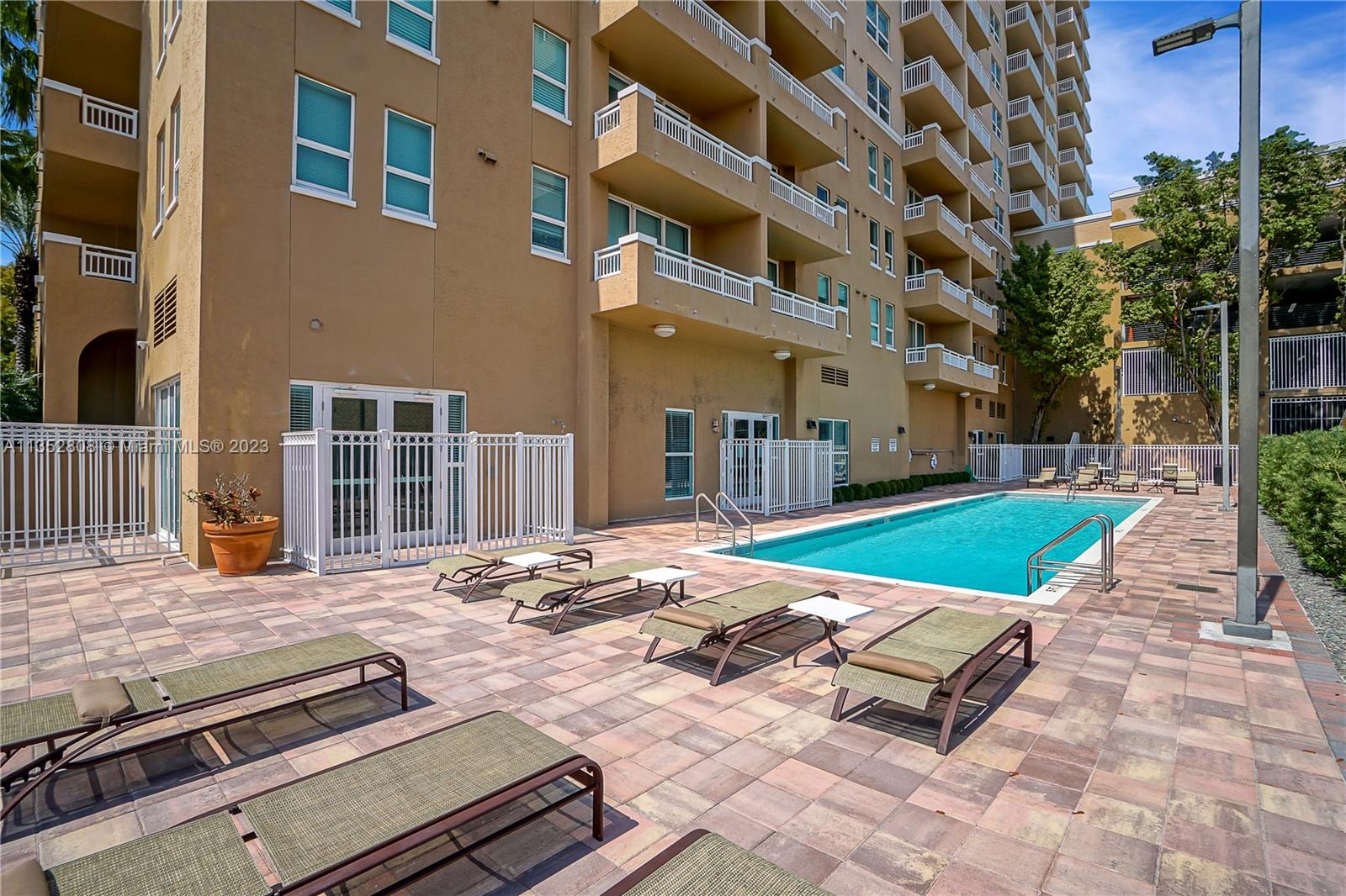 2665 Southwest 37th Avenue, Unit 914 Miami, FL 33133 - Photo 24 of 30 a view of a backyard with brick wall and potted plants