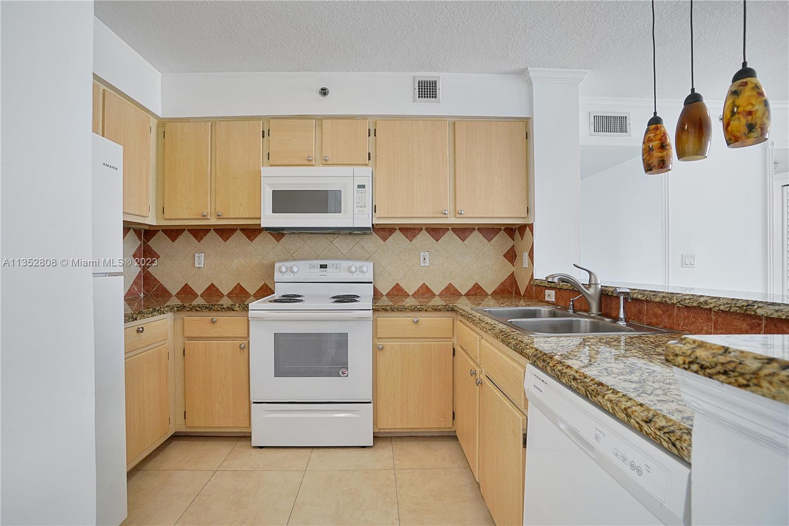 2665 Southwest 37th Avenue, Unit 914 Miami, FL 33133 - Photo 7 of 30 a kitchen with a sink stove and cabinets