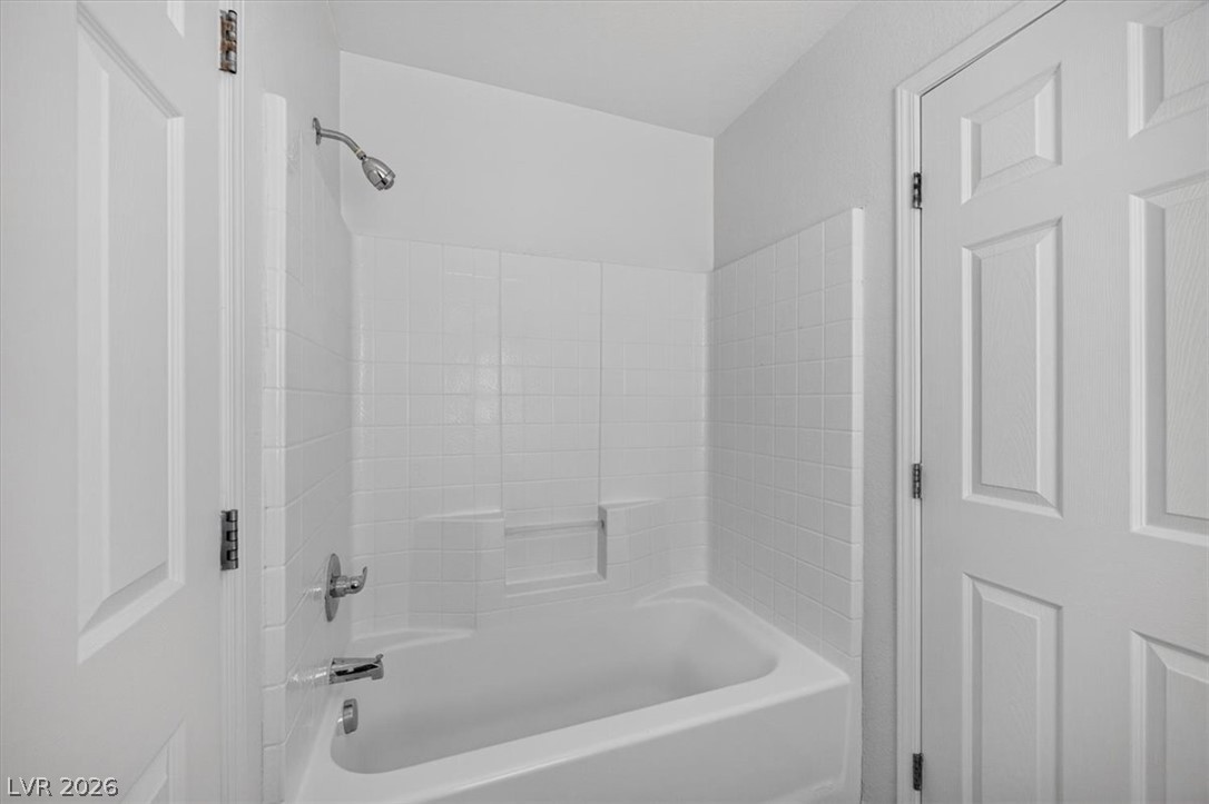 552 Albacate Street Henderson, NV 89015 - Photo 34 of 40 A pristine white tiled shower-tub combination provides a refreshing retreat.