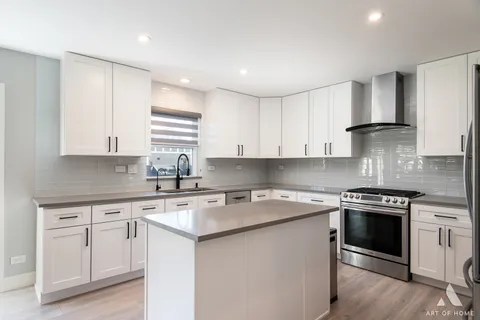a kitchen with white cabinets stainless steel appliances and sink