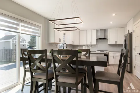 a kitchen with a dining table chairs and refrigerator