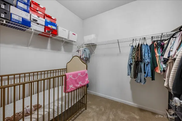 a view of walk in closet with clothes and shoes