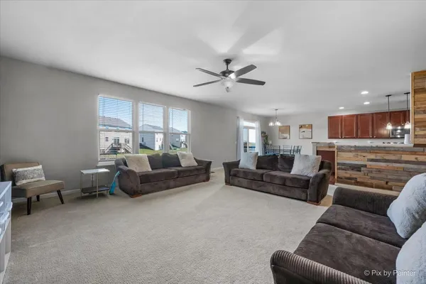 a living room with furniture ceiling fan and a rug