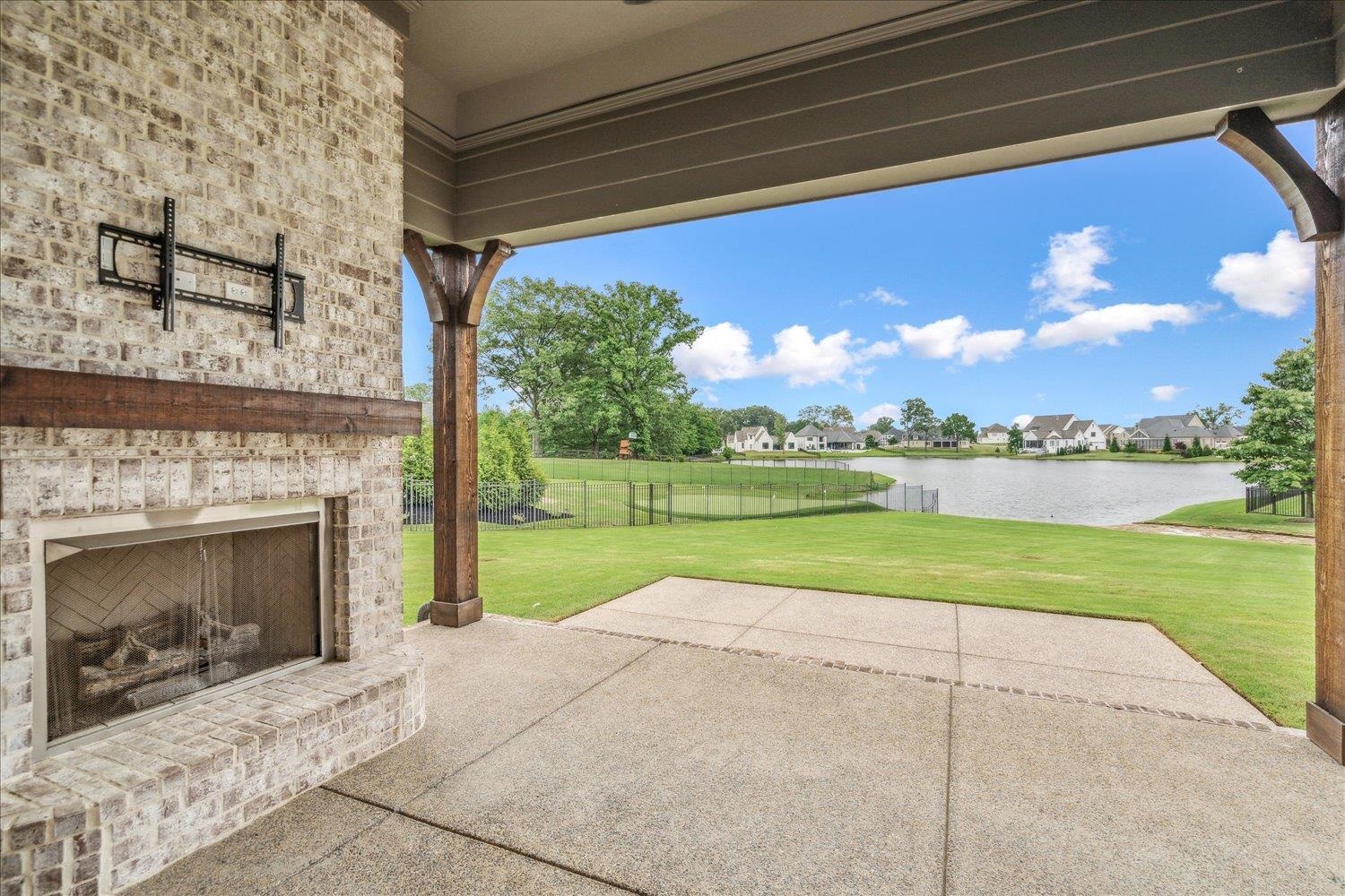 680 Magnolia Lane Piperton, TN 38017 - Photo 35 of 40 View of patio / terrace featuring an outdoor brick fireplace and a water view.