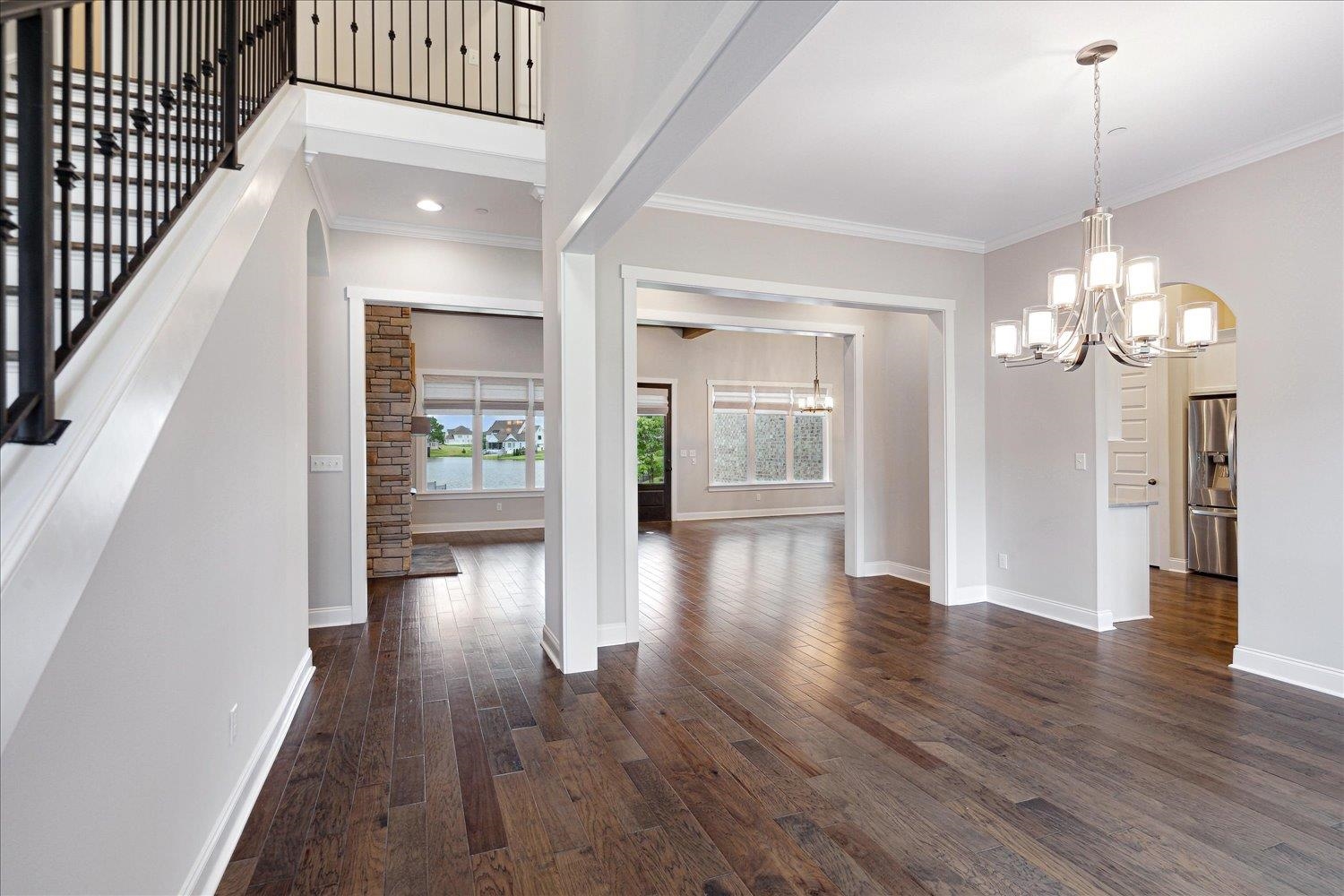 680 Magnolia Lane Piperton, TN 38017 - Photo 5 of 40 Foyer featuring a chandelier, dark wood-type flooring, baseboards, ornamental molding, and stairs