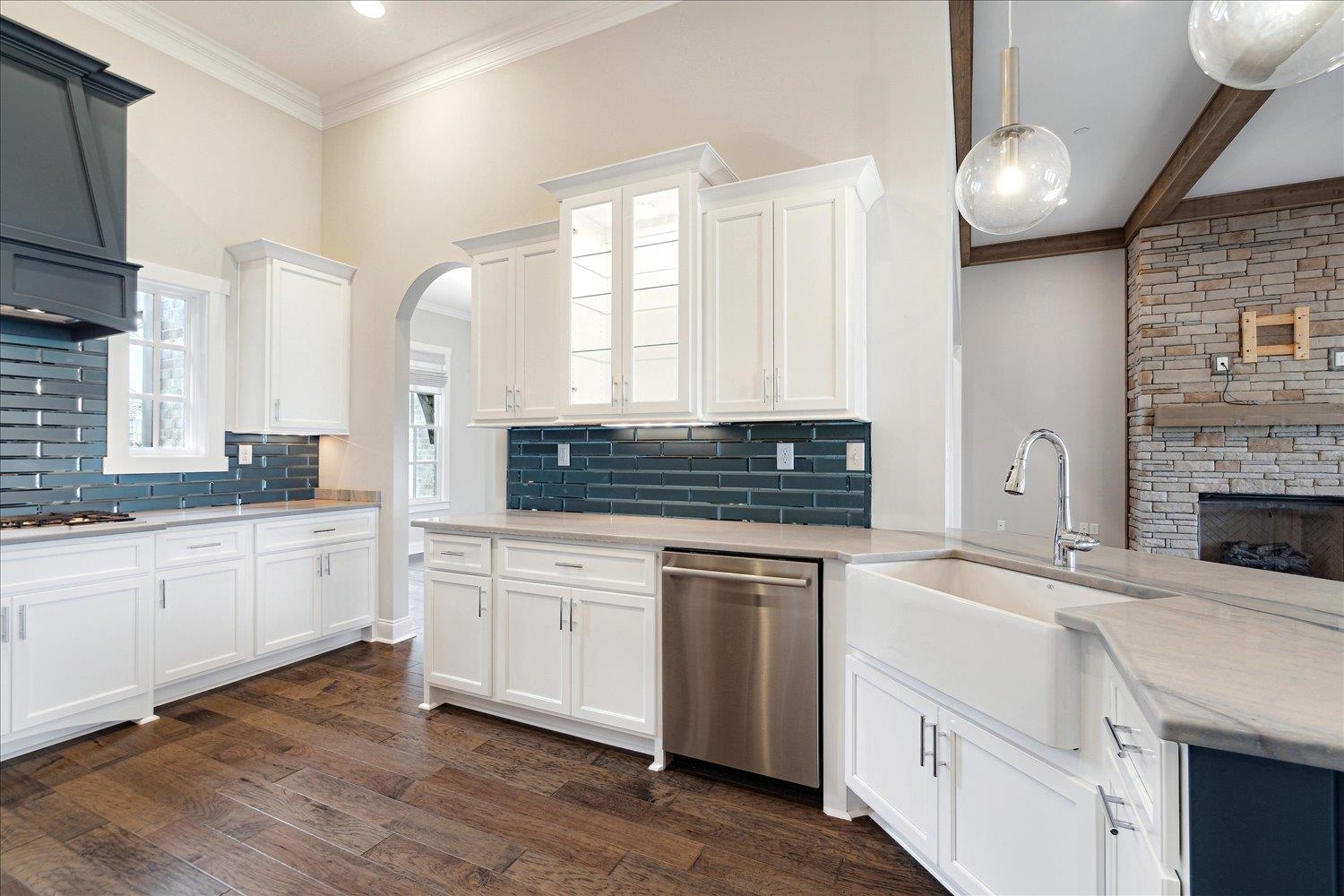 680 Magnolia Lane Piperton, TN 38017 - Photo 8 of 40 Kitchen featuring stainless steel dishwasher, a sink, tasteful backsplash, white cabinets, and glass insert cabinets