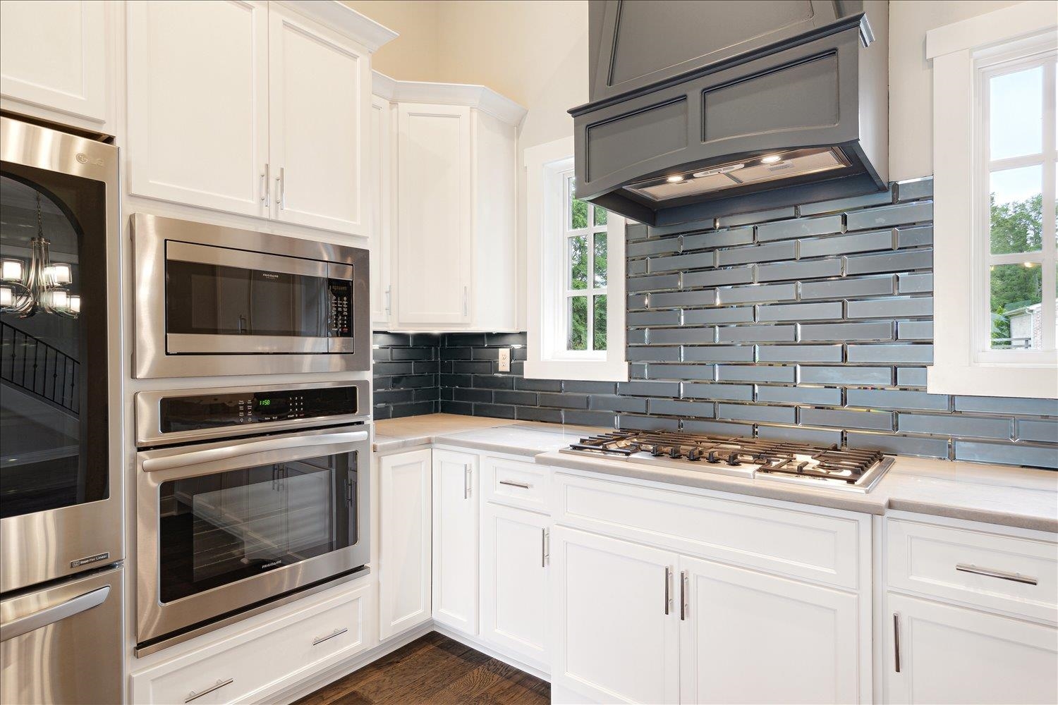 680 Magnolia Lane Piperton, TN 38017 - Photo 9 of 40 Kitchen with appliances with stainless steel finishes, light countertops, range hood, and tasteful backsplash