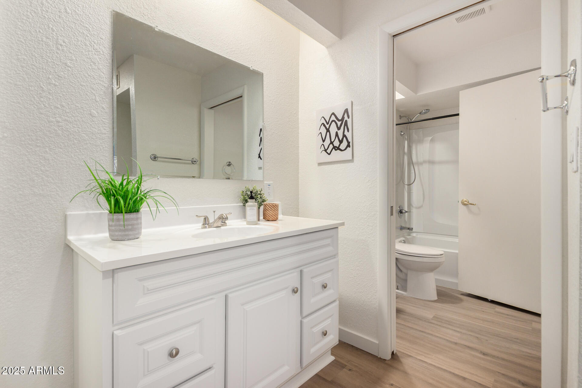 700 East Mesquite Circle, Unit L107 Tempe, AZ 85288 - Photo 13 of 26 a bathroom with a sink a toilet and a large mirror