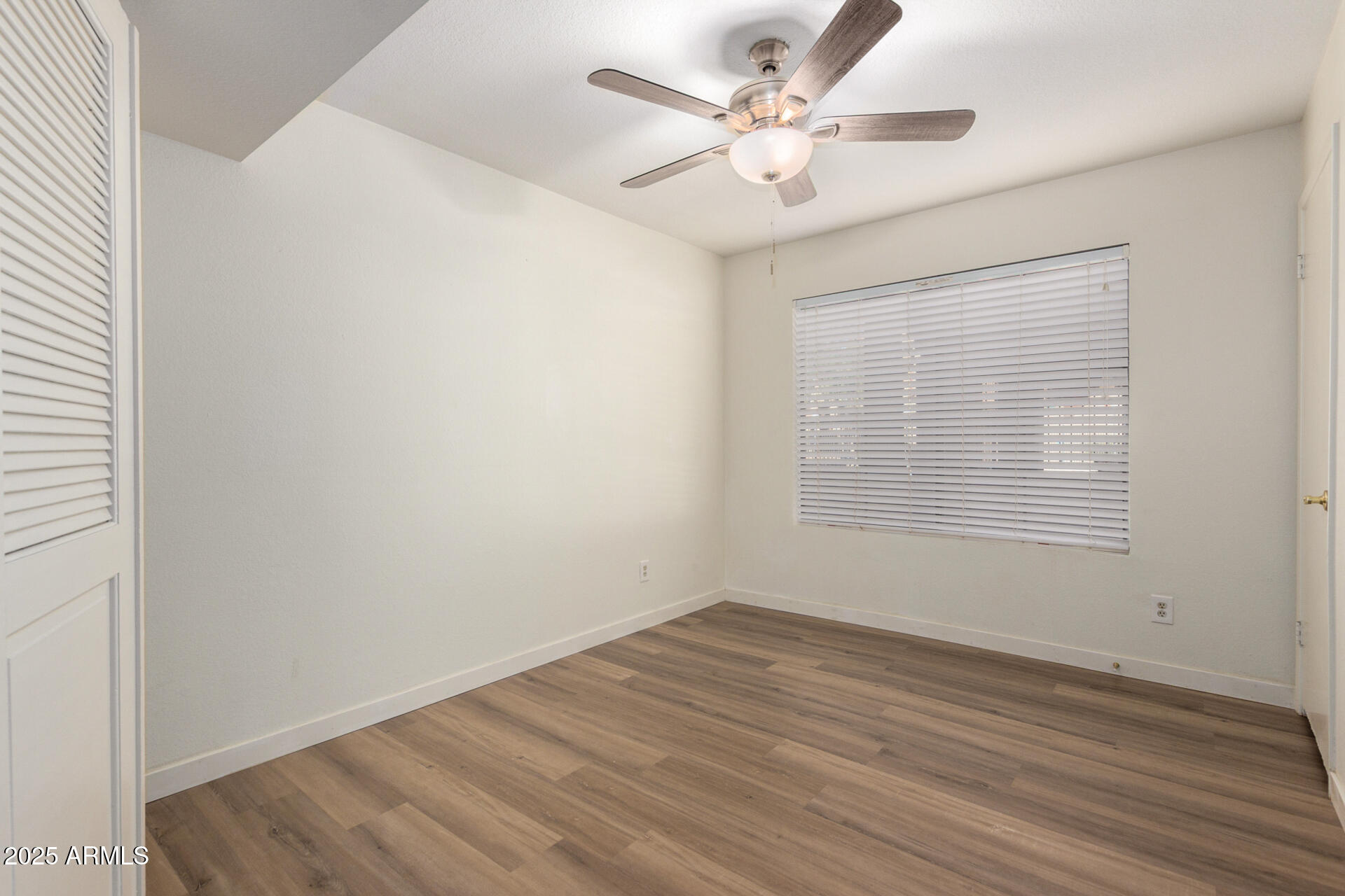 700 East Mesquite Circle, Unit L107 Tempe, AZ 85288 - Photo 19 of 26 an empty room with wooden floor and windows