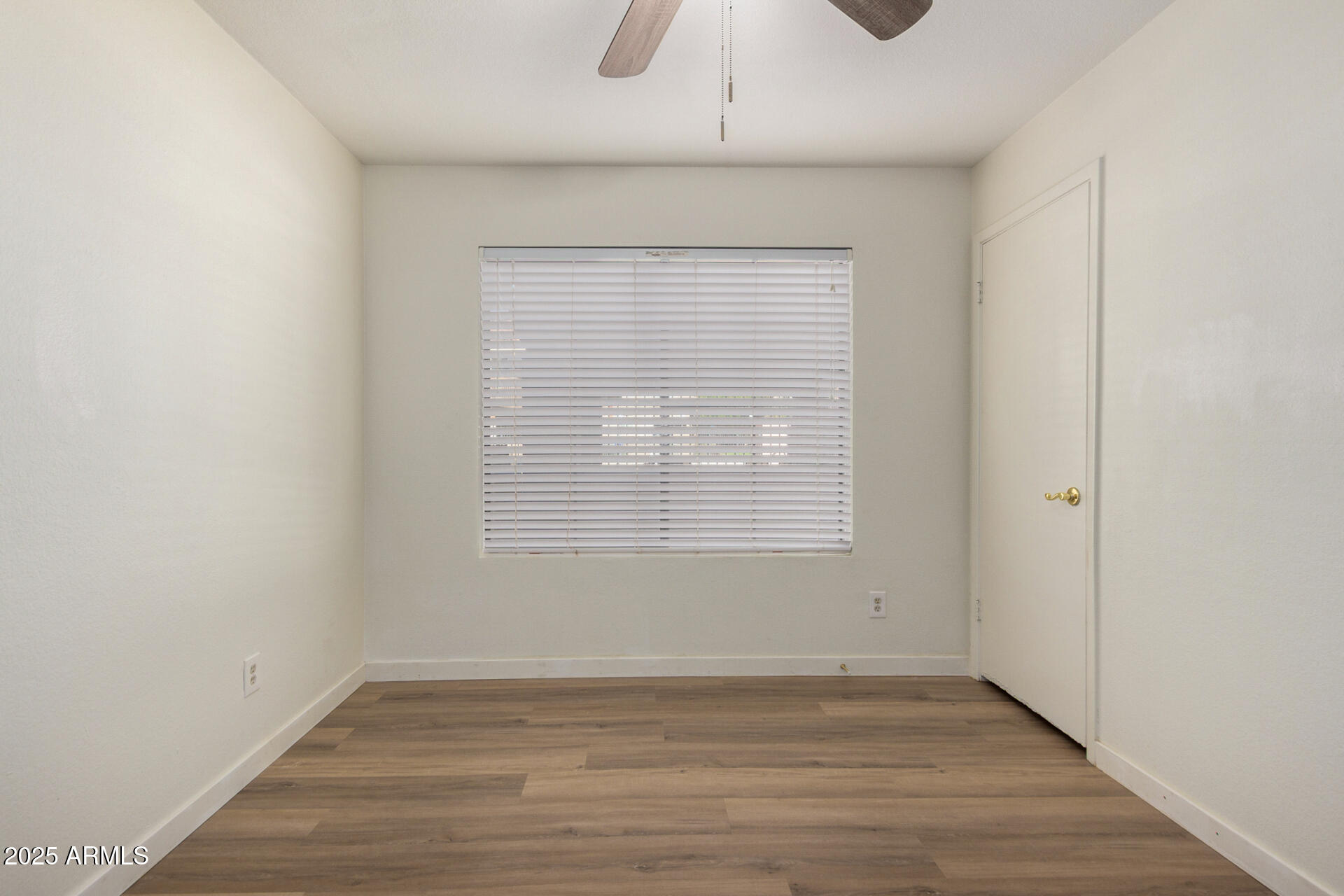 700 East Mesquite Circle, Unit L107 Tempe, AZ 85288 - Photo 20 of 26 a view of an empty room with wooden floor and a window