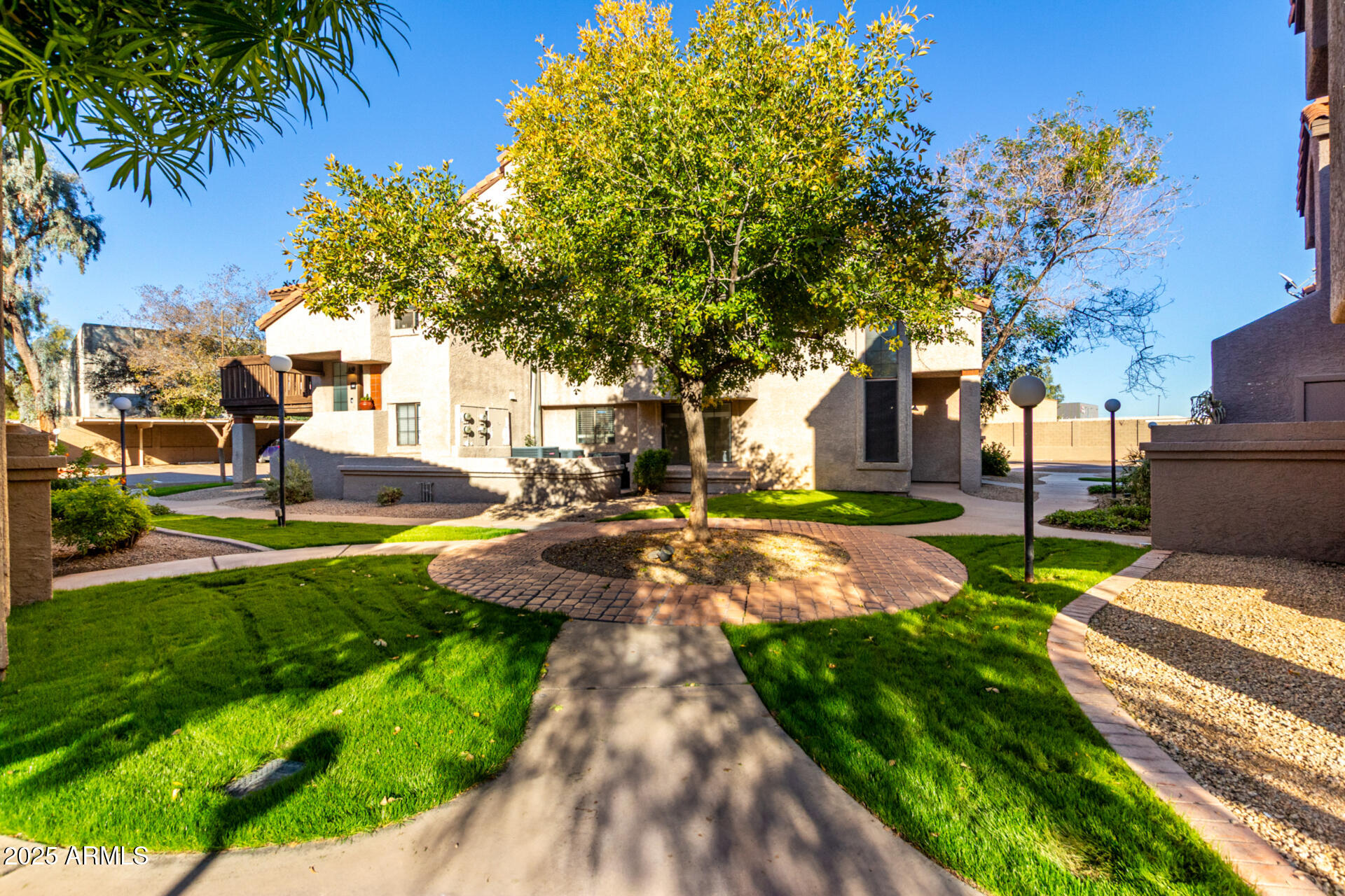 700 East Mesquite Circle, Unit L107 Tempe, AZ 85288 - Photo 2 of 26 a view of a yard with plants and large trees
