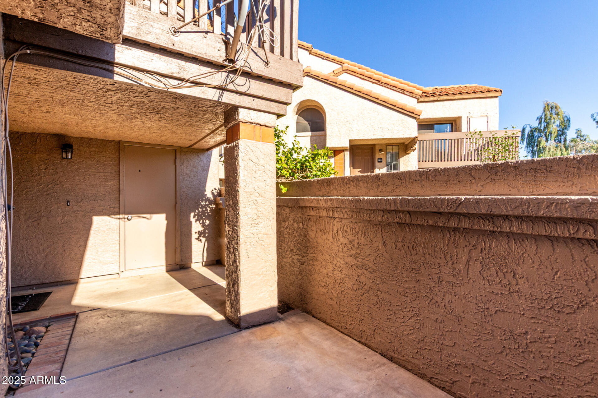700 East Mesquite Circle, Unit L107 Tempe, AZ 85288 - Photo 3 of 26 a view of a building with a door and wooden roof
