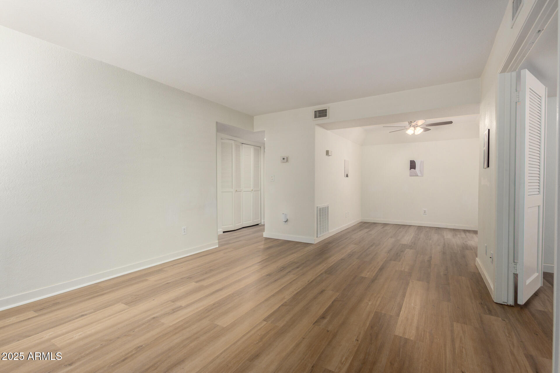 700 East Mesquite Circle, Unit L107 Tempe, AZ 85288 - Photo 5 of 26 a view of an empty room and wooden floor