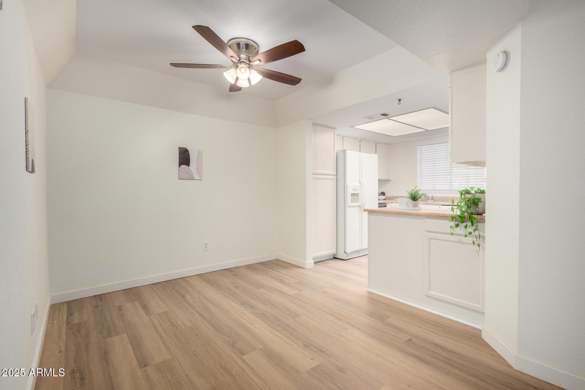 700 East Mesquite Circle, Unit L107 Tempe, AZ 85288 - Photo 6 of 26 a view of a kitchen with wooden floor and a ceiling fan