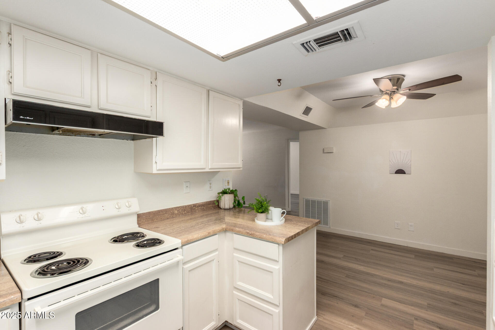 700 East Mesquite Circle, Unit L107 Tempe, AZ 85288 - Photo 8 of 26 a kitchen with a stove cabinets and wooden floor