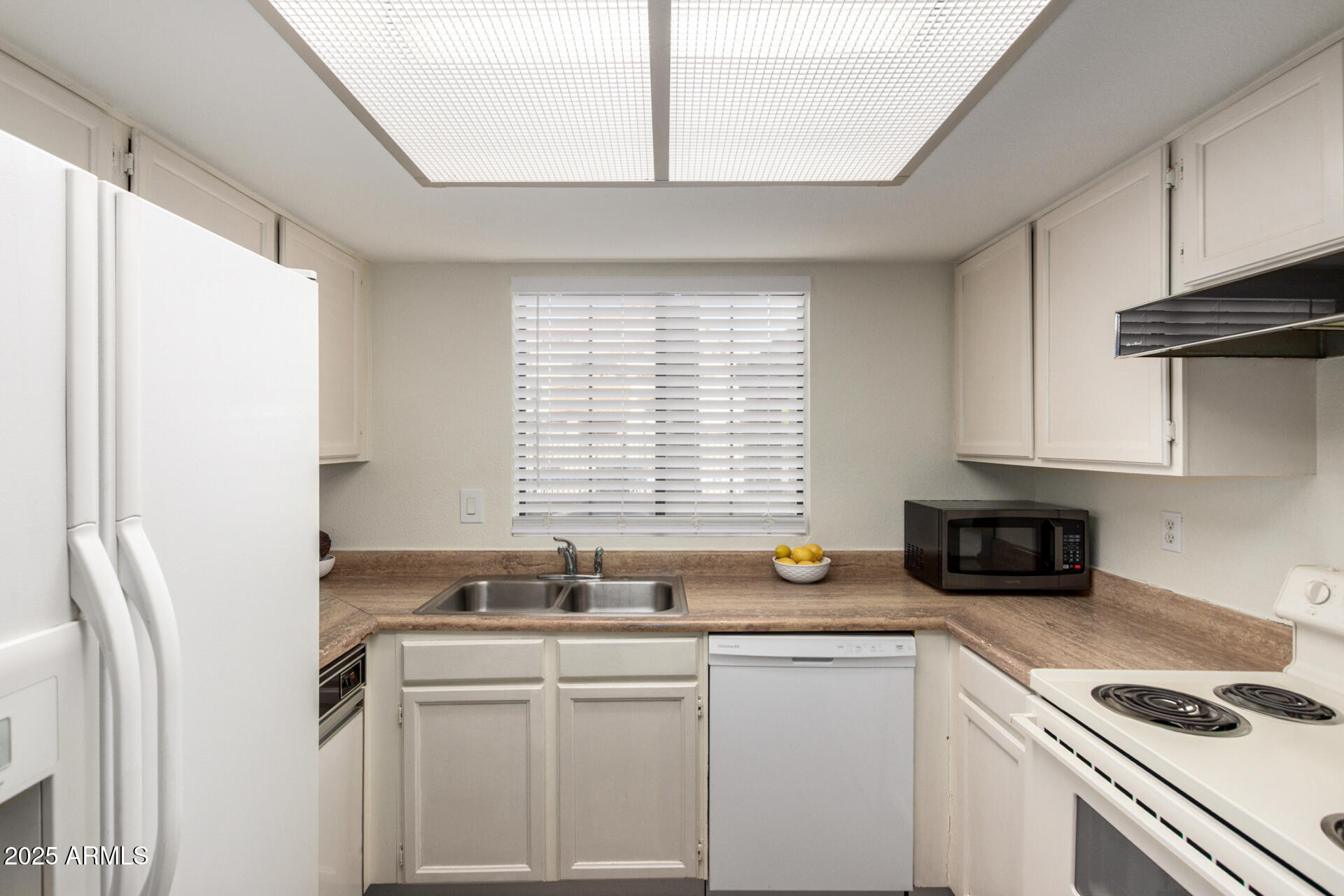 700 East Mesquite Circle, Unit L107 Tempe, AZ 85288 - Photo 9 of 26 a kitchen with a sink cabinets and window
