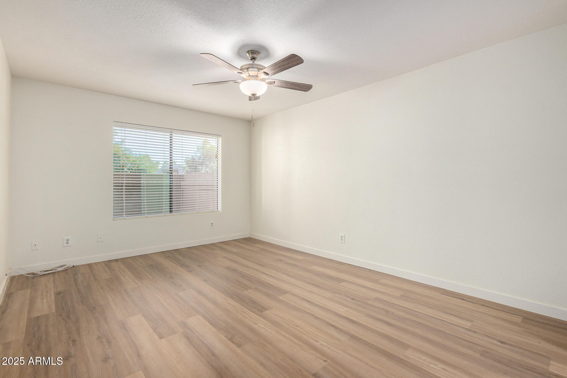 700 East Mesquite Circle, Unit L107 Tempe, AZ 85288 - Photo 10 of 26 a view of an empty room with wooden floor and a window