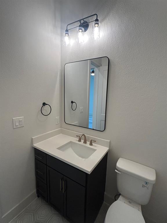 415 East Burks Street Pilot Point, TX 76258 - Photo 12 of 13 a bathroom with a toilet sink and mirror
