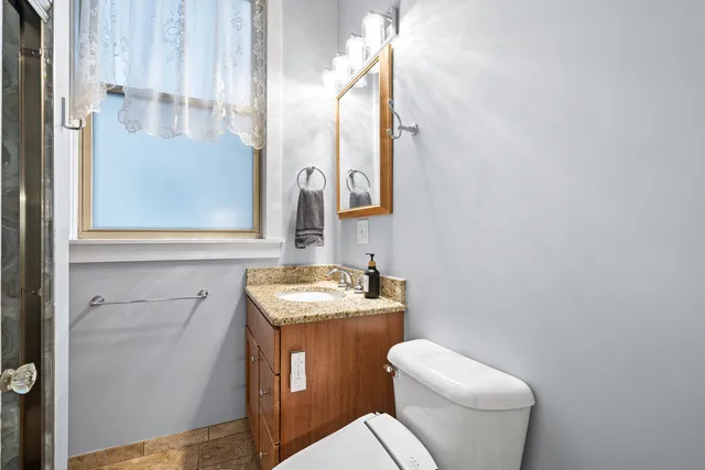 a bathroom with a toilet sink and mirror