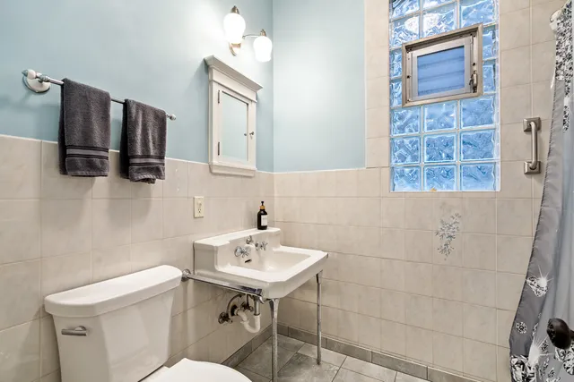 a bathroom with a sink a toilet and mirror