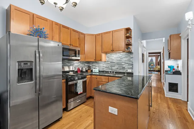 a kitchen with stainless steel appliances granite countertop a refrigerator a stove and a sink