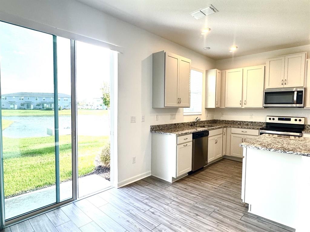 1025 Spring Palms Loop Orlando, FL 32828 - Photo 4 of 9 a kitchen with a stove a sink and a microwave