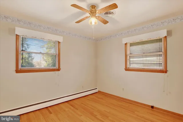 a view of an empty room with a window and a ceiling fan