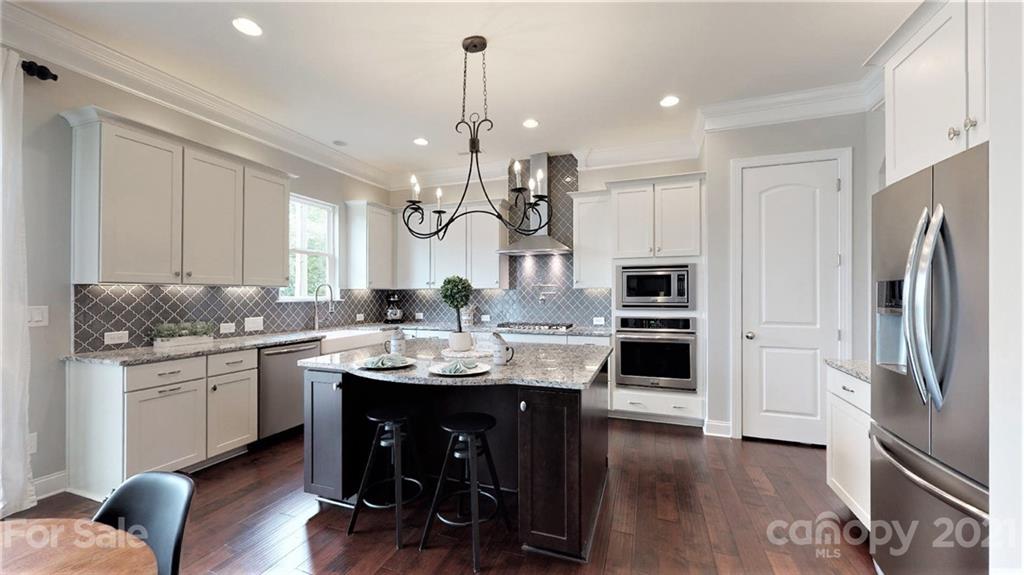 1000 Fallondale Road Waxhaw, NC 28173 - Photo 11 of 48 a kitchen with stainless steel appliances kitchen island granite countertop a stove a sink a refrigerator and a dining table with wooden floor