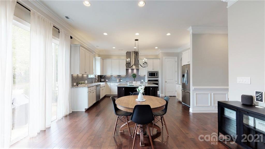 1000 Fallondale Road Waxhaw, NC 28173 - Photo 19 of 48 a kitchen with a dining table chairs refrigerator and cabinets