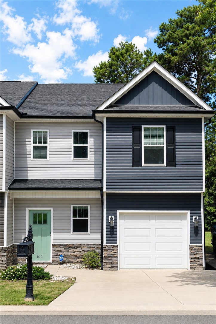 A well-maintained facade features a stylish mint green door and an integrated garage.