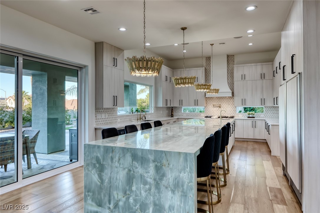 2309 Prometheus Court Henderson, NV 89074 - Photo 13 of 86 Kitchen featuring a kitchen bar, light stone counters, light wood-style flooring, and recessed lighting