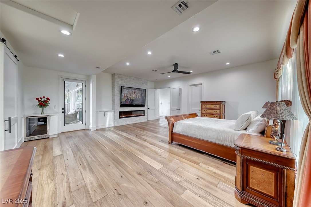 2309 Prometheus Court Henderson, NV 89074 - Photo 29 of 86 Bedroom with wine cooler, light wood-style flooring, recessed lighting, a ceiling fan, and a fireplace