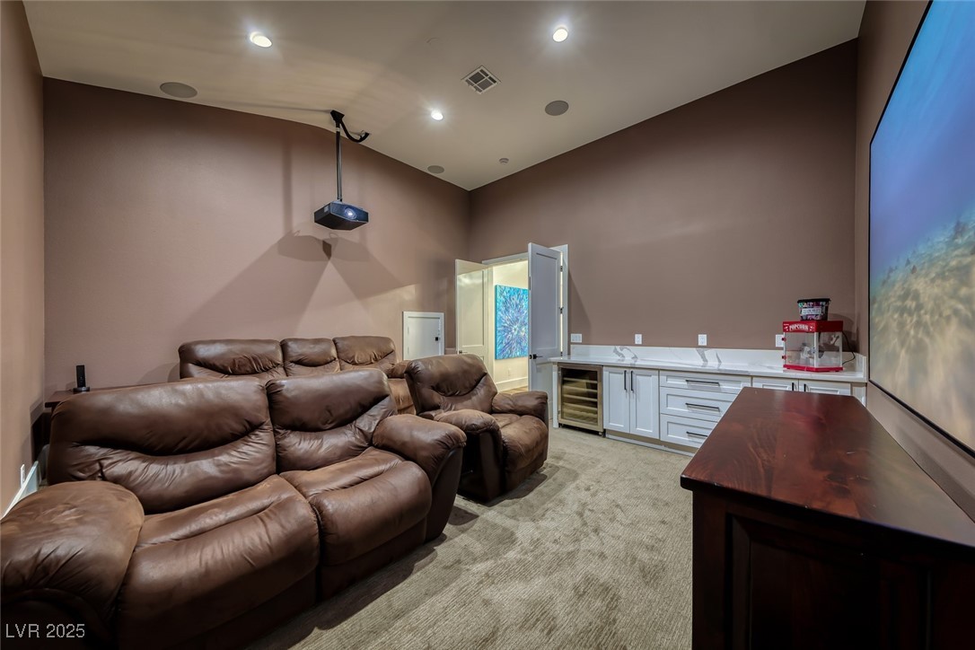 2309 Prometheus Court Henderson, NV 89074 - Photo 36 of 86 Home theater featuring light carpet, bar, wine cooler, lofted ceiling, and recessed lighting