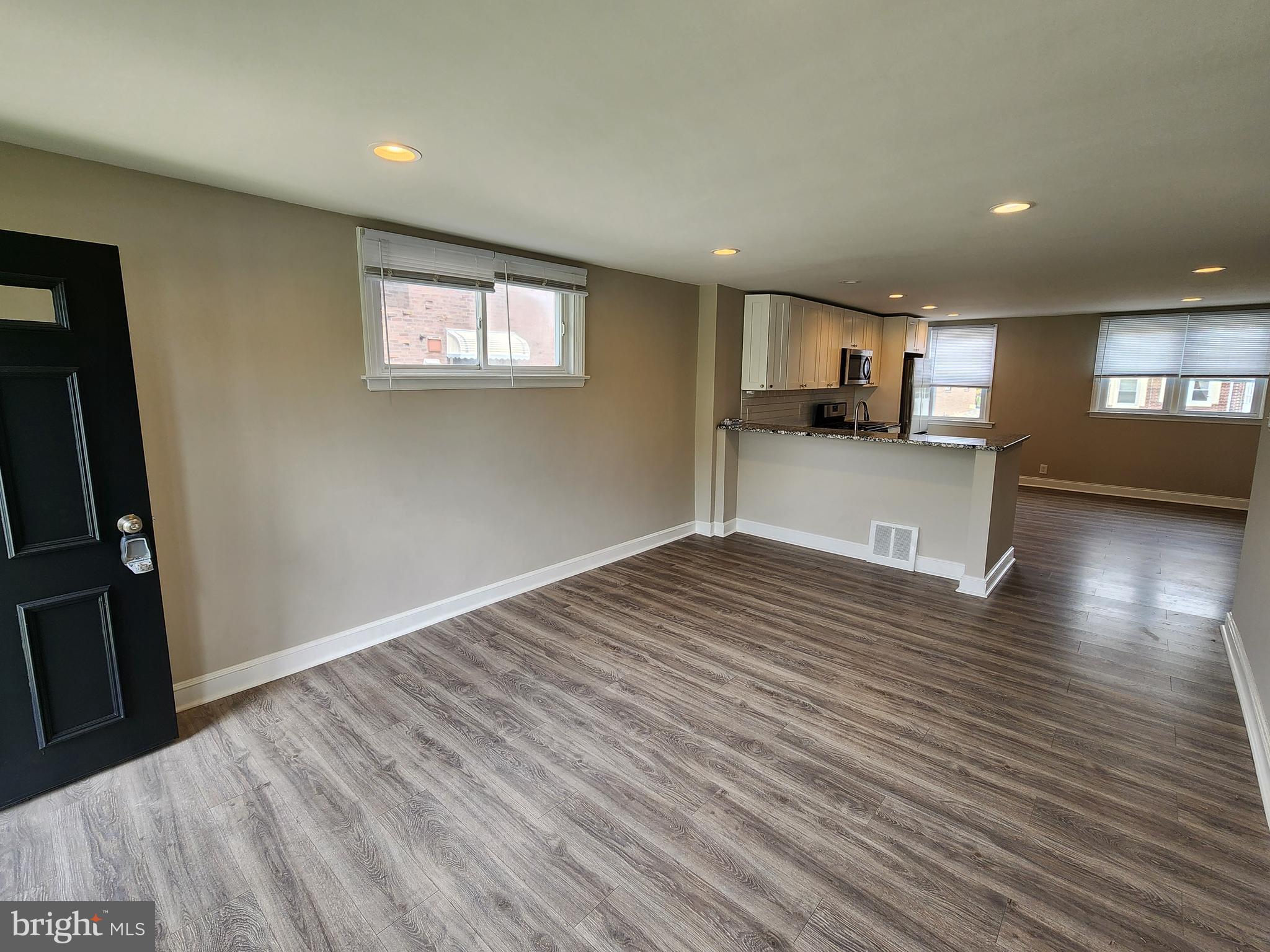 201 Westbridge Road Glenolden, PA 19036 - Photo 4 of 24 an empty room with wooden floor a flat screen tv and windows