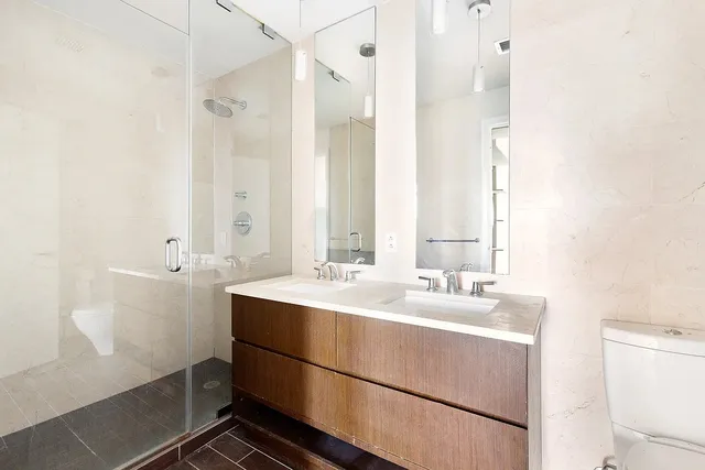 a bathroom with a double vanity sink mirror and toilet