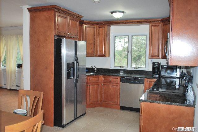 39 Willow Road Rocky Point, NY 11778 - Photo 1 of 1 a kitchen with stainless steel appliances granite countertop a refrigerator a sink a stove a washer dryer and a refrigerator