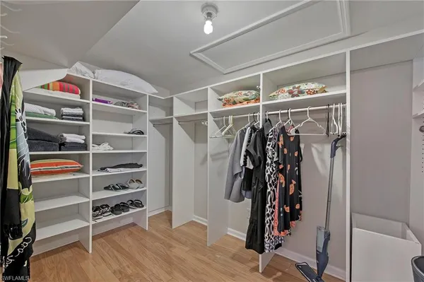 a view of walk in closet with clothes and shoes