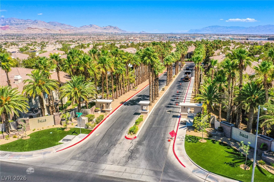 9050 West Warm Springs Road, Unit 1011 Las Vegas, NV 89148 - Photo 31 of 32 An aerial perspective reveals a palm-lined community entrance with scenic mountain views.