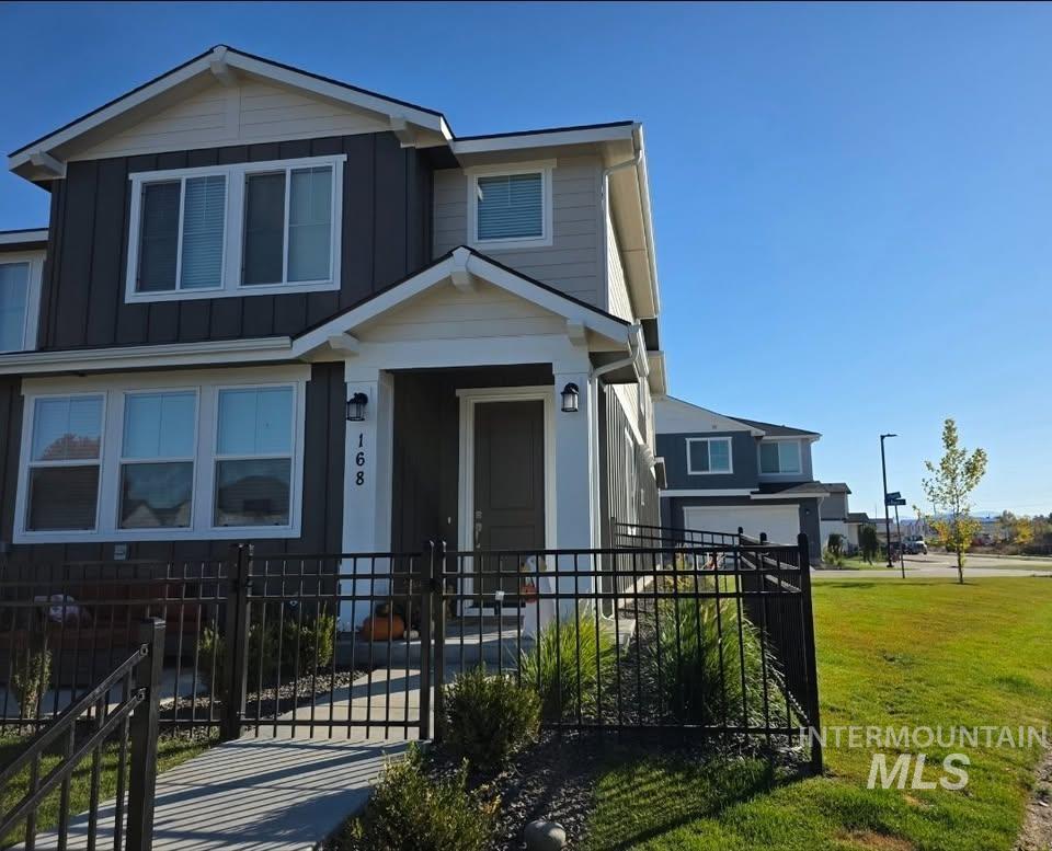 View of front of property featuring a gate, a fenced front yard, and board and batten siding